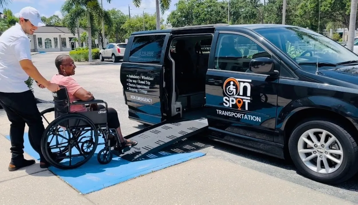 Woman in wheelchair being pushed up ramp into On Spot Transportation van.