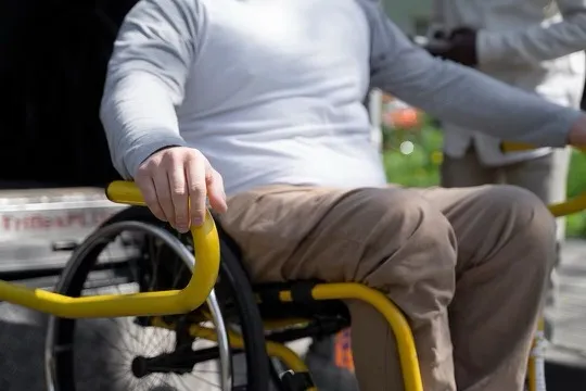 Man sitting in wheelchair using lift to enter transport.